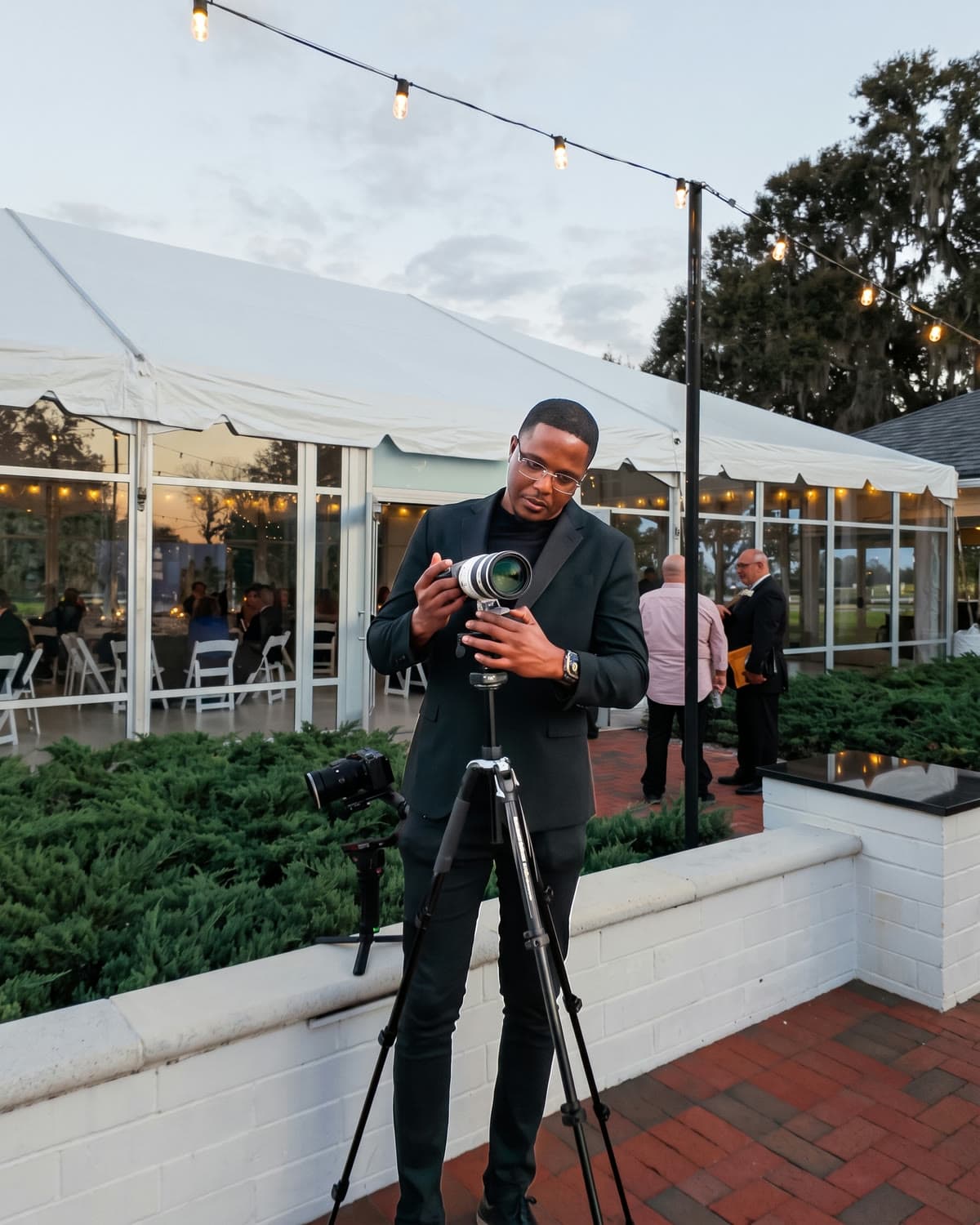 Filming a wedding reception from a tripod at dusk