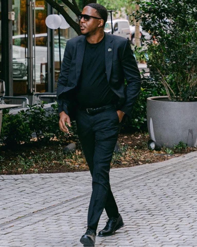 Portrait of the Labif Filmhouse filmmaker, in a dark suit on a city street